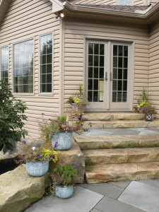 Coordinated containers echo the color of the stone paving.